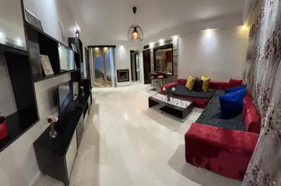 a living room with a red couch and blue pillows at Studio de luxe in Casablanca