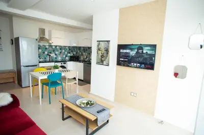 a kitchen and a living room with a couch and a table at My Cosy Place Rabat - Appartements à 50m de la gare Agdal TGV in Rabat