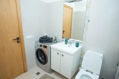 a bathroom with a washing machine and a toilet at My Cosy Place Rabat - Appartements à 50m de la gare Agdal TGV in Rabat