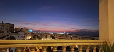 a view of a city at night from a balcony at Grand appartement de luxe vue mer in Casablanca
