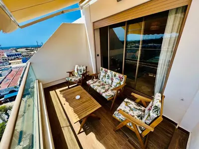 a balcony with two chairs and a coffee table at OceanParc - Vue sur Mer et Parc 24H Sécurité in Mohammedia