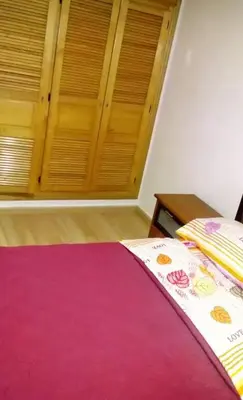 a bedroom with a bed with pink sheets and wooden shutters at Housse coral famille in Casablanca