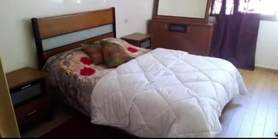 a bedroom with a bed with a white comforter at Housse coral famille in Casablanca
