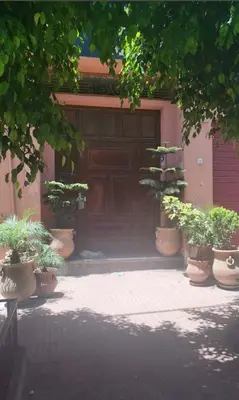a building with a large wooden door with potted plants at Housse coral famille in Casablanca