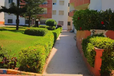 a sidewalk in front of a building with bushes at Mohammedia vive les vacances in Mohammedia