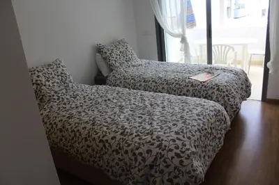 a couch in a room with a blanket and a book at Fermer Appartement dans résidence Paradis Beach in Mohammedia