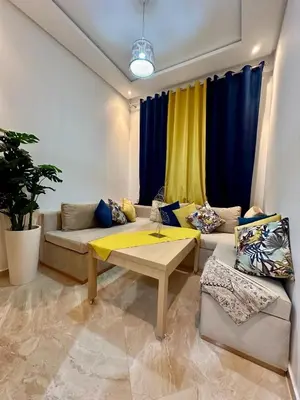 a living room with a couch and a table at Apparemment de luxe vue piscine in Bouznika