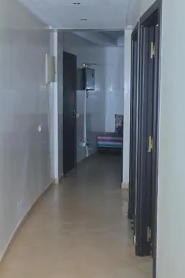 a hallway with two doors and a couch in a room at Appartement au centre ville in Bouznika