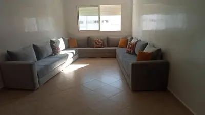 a living room with two couches and a window at Appartement au centre ville in Bouznika