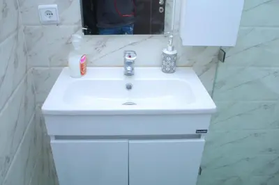 a white sink in a bathroom with a mirror at Appartement - Bouznika Centre in Bouznika