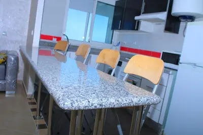 a kitchen with a counter with chairs and a table at BOUZNIKA au centre de Bouznika in Bouznika