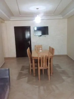 a dining room with a wooden table and chairs at BOUZNIKA Appartement in Bouznika