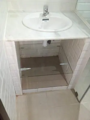 a bathroom with a sink and a mirror under it at BOUZNIKA Appartement in Bouznika