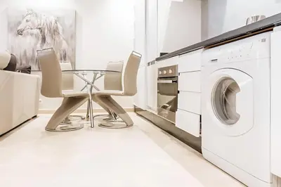 a white laundry room with a table and a washing machine at STUDIO HAUT STANDING A RACINE near twin center in Casablanca