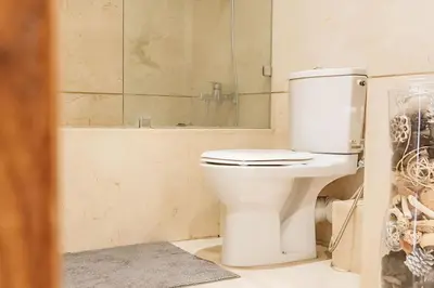 a bathroom with a toilet with a mirror and a tub at STUDIO HAUT STANDING A RACINE near twin center in Casablanca
