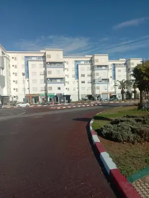 an empty street in front of a large building at Superbe appartement Bouznika in Bouznika