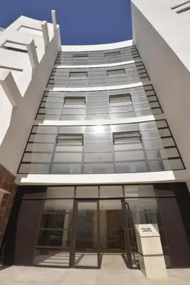 a tall building with a lot of glass windows at Au Cœur de la ville de Bouznika in Bouznika