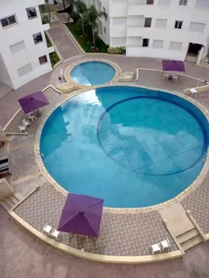 an overhead view of a large swimming pool with umbrellas at La Belle Echappée in Bouznika