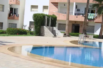 a swimming pool in front of a building at La résidence des vagues in Mohammedia
