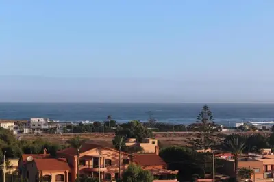 a city with houses and the ocean in the background at Apparentement des jardins paisibles in Mohammedia