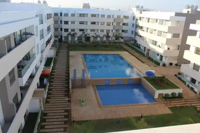 an overhead view of a swimming pool between two buildings at Apparentement des jardins paisibles in Mohammedia