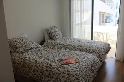 a bedroom with a bed and a chair and a window at Appartement du bonheur Paradise in Mohammedia