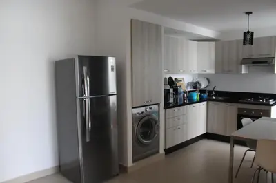 a kitchen with a refrigerator and a washing machine at Appartement du bonheur Paradise in Mohammedia