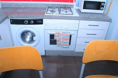 a kitchen with a stove and a washing machine at BOUZNIKA T1 in Bouznika