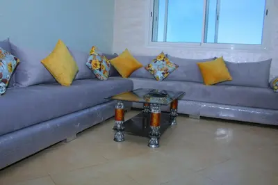 a couch with pillows and a table in a living room at BOUZNIKA T2 in Bouznika