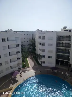 a large swimming pool in front of some buildings at Le chant de la rivière BOUZNIKA in Bouznika