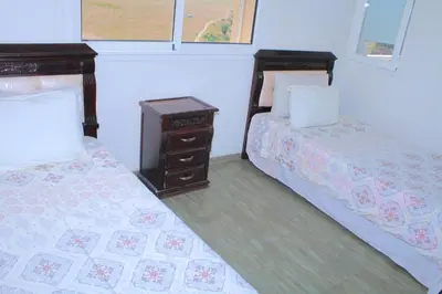 a bedroom with two beds and a night stand at Le paradis du pêcheur BOUZNIKA in Bouznika