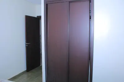 a closet with a wooden door in a room at Le paradis du pêcheur BOUZNIKA in Bouznika