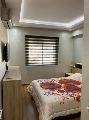 a bedroom with a large bed and a window at Magnifique F3 rénové Fibre, Parking & excellente desserte in Casablanca