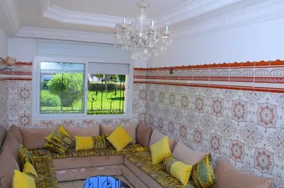 a living room with a couch and a chandelier at Les temps heureux MOHAMMEDIA in Mohammedia