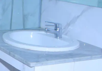 a bathroom sink with a silver faucet on a counter at Les temps heureux MOHAMMEDIA in Mohammedia