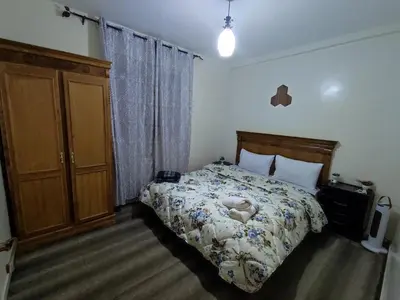a bedroom with a bed and a dresser in it at Spacious 2BR Ground-Floor Apartment Parking & Free Wi-Fi in Casablanca