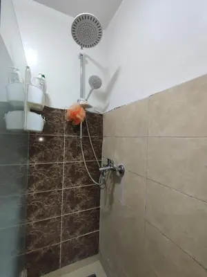 a shower with a shower head in a bathroom at Spacious 2BR Ground-Floor Apartment Parking & Free Wi-Fi in Casablanca