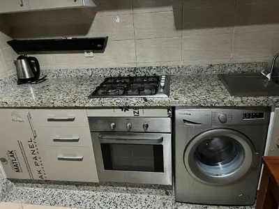 a kitchen with a stove and a washing machine at Résidence jnane California in Casablanca