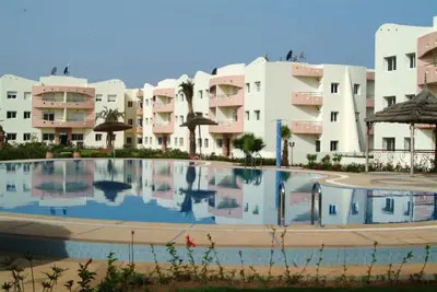 a large swimming pool in front of some apartment buildings at Appartement Mimousa in Mohammedia