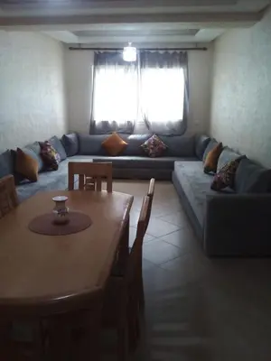 a living room with a table and a couch at BOUZNIKA 78 in Bouznika