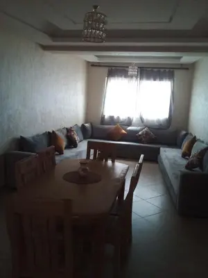 a living room with a table and a couch at BOUZNIKA 78 in Bouznika