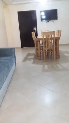 a dining room with a table and chairs and a television at Séjour à Bouznika in Bouznika