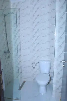 a bathroom with a toilet and a glass shower at BOUZNIKA CH1 98 in Bouznika