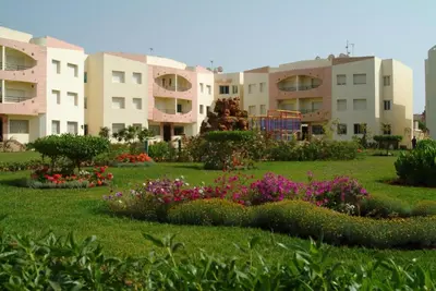 a park with flowers in front of some buildings at MOHAMMEDIA Appartement avec 3 piscines et prés de plage in Mohammedia