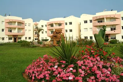 a view of a building with flowers in a yard at MOHAMMEDIA Résidence avec piscines in Mohammedia
