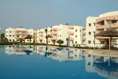 a large pool in front of some apartment buildings at Super Appartement MOHAMMEDIA in Mohammedia