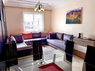 a living room with a couch and a table at Sab 8 - Amazing view. 2 bedrooms in front of the mosque Hassan. Perfect location in Casablanca