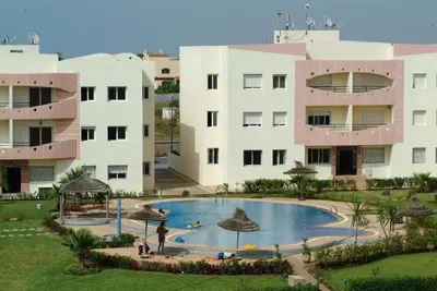 a resort with a large pool in front of a building at Appartement dans une belle résidence à Mohammedia in Mohammedia