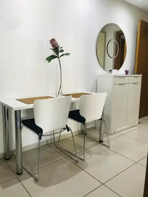 a table with two chairs and a vase with a flower at Melrose Beαch Aρραrt Pοοl Vieω in Casablanca