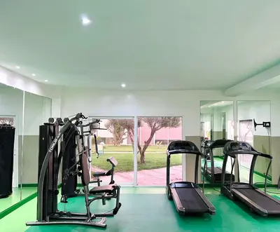 a gym with treadmills and ellipticals and a window at Melrose Beαch Aρραrt Pοοl Vieω in Casablanca